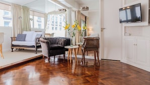 A modern living room with a sofa, armchairs, a round table, and a television. - BT Homes - Recoleta, Ayacucho (Buenos Aires)