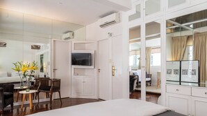 A hotel room with a large bed, a TV, a desk with a chair, a mirror, and a wardrobe. - BT Homes - Recoleta, Ayacucho (Buenos Aires)