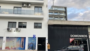 Ein Gebäude mit einer großen Schanze für 'DOMENIKOS' und einem Parkplatzschild.