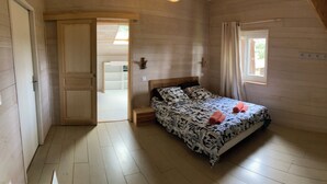 Ein Schlafzimmer mit einem Bett, einem Fenster und einer Tür zu einem anderen Raum.