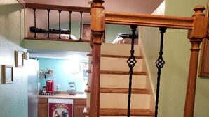A wooden staircase with a decorative balustrade leading to a second floor.
