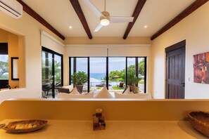 A room with a large window, a ceiling fan, and a view of the outdoors.
