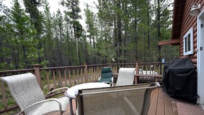 A wooden deck with outdoor seating and a view of a forest. - *New Listing*|Sleeps 6| 25 Miles to Yellowstone! (Island Park)