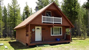 A wooden cabin with a porch, a door, and a window. - *New Listing*|Sleeps 6| 25 Miles to Yellowstone! (Island Park)