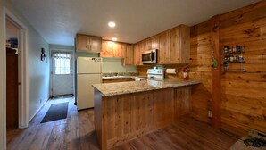 A kitchen with wooden cabinets, a granite countertop, a refrigerator, a microwave, and a stove. - *New Listing*|Sleeps 6| 25 Miles to Yellowstone! (Island Park)