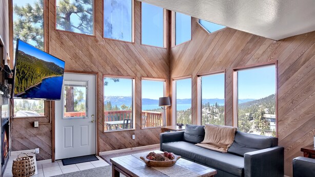 A spacious living area with large windows, a fireplace, and a cozy seating arrangement.