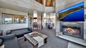 A spacious living area with a fireplace, a large TV mounted on the wall, and a cozy seating arrangement.