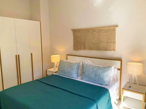 A neatly arranged hotel room with a bed, two bedside tables, and a wardrobe. - The Waterclub by Horizon Holidays (Black River)