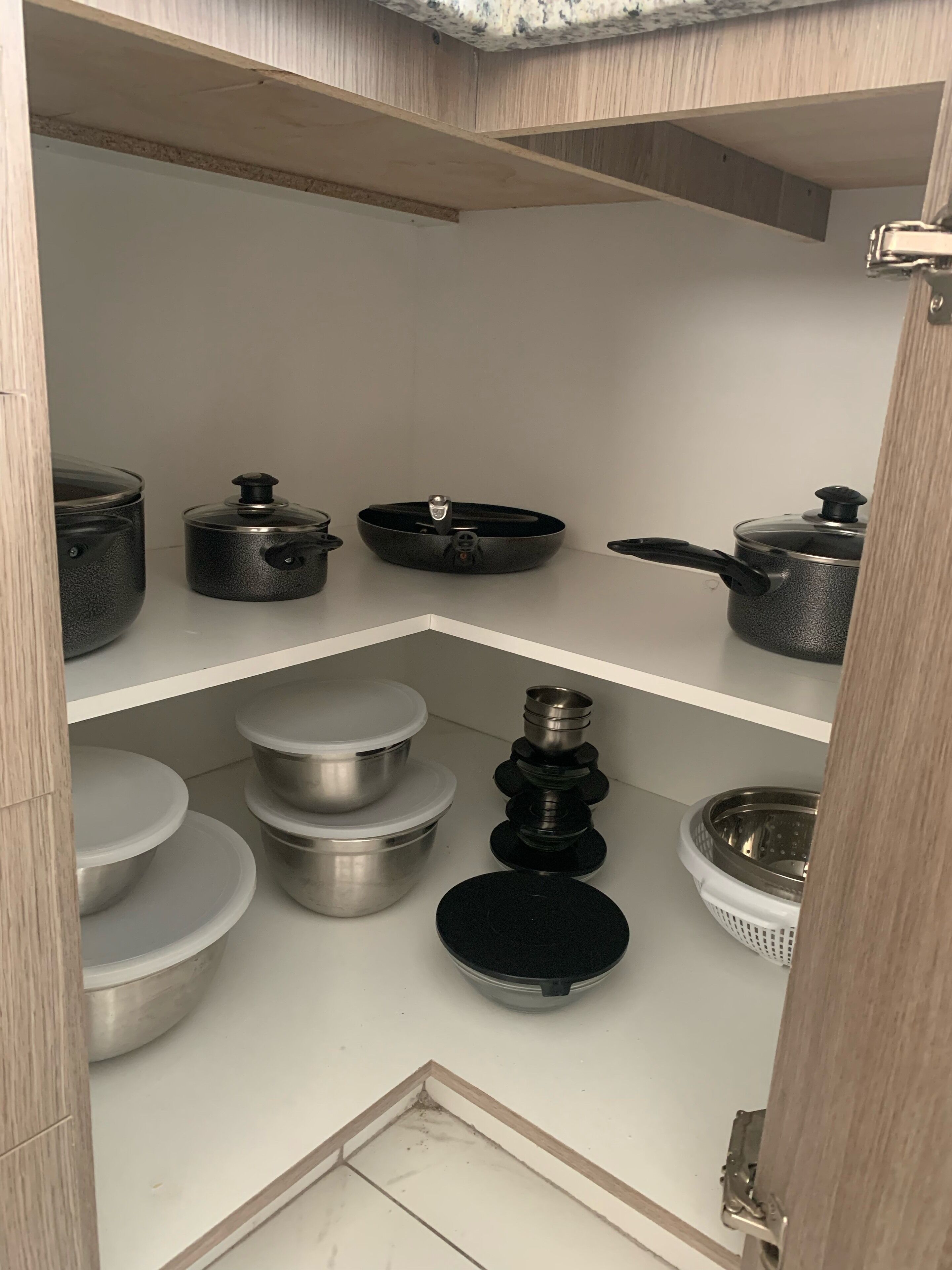 Eine Küche mit verschiedenen Töpfen und Pfannen auf Regalen.