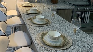 A modern kitchen with a granite countertop, white cabinets, and a microwave. - Brand New Beach House-- Terrace Beach View (Rosarito)