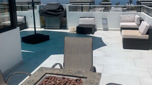 A rooftop patio with outdoor seating, a fire pit, and a view of the ocean. - Brand New Beach House-- Terrace Beach View (Rosarito)