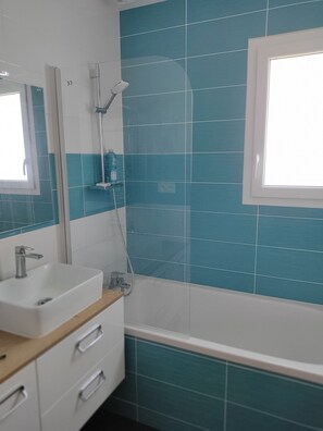 Een bad, een haardroger, handdoeken, toiletpapier