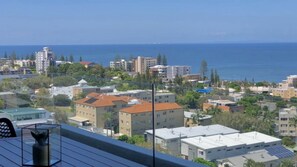 A coastal cityscape with buildings, a clear sky, and the sea in the background. - Kings Beach Apt: Ocean Views & Rooftop (KINGS BEACH)