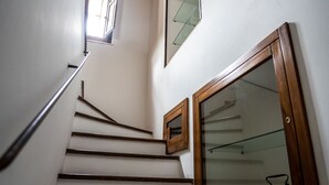 Un escalier avec des marches en bois et une porte en verre en bas.