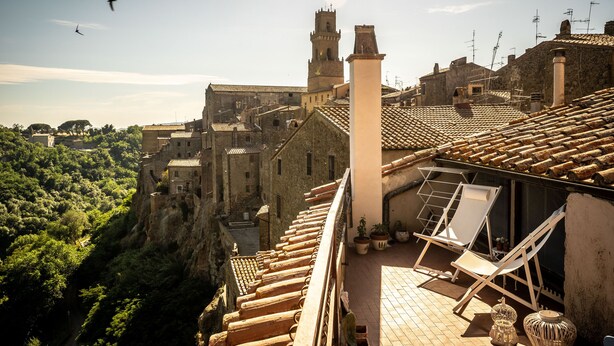 Une terrasse sur le toit offrant une vue sur une ville historique, avec notamment une tour et un château.