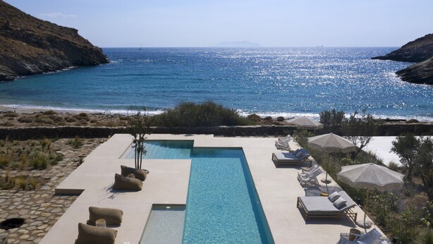 A pool with lounge chairs and umbrellas overlooking the sea. - Kea Retreat (Kea)
