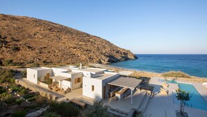 A coastal property with a pool, outdoor seating, and a view of the sea. - Kea Retreat (Kea)