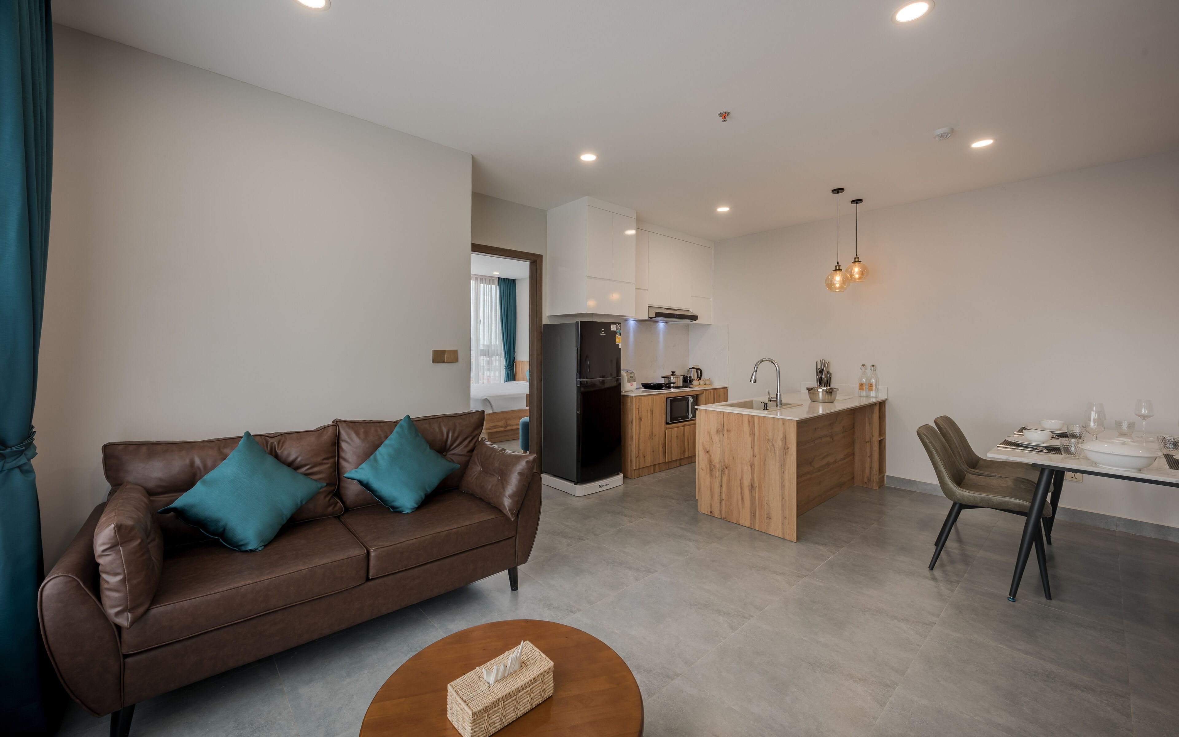A modern apartment with a living room, kitchenette, and dining area.