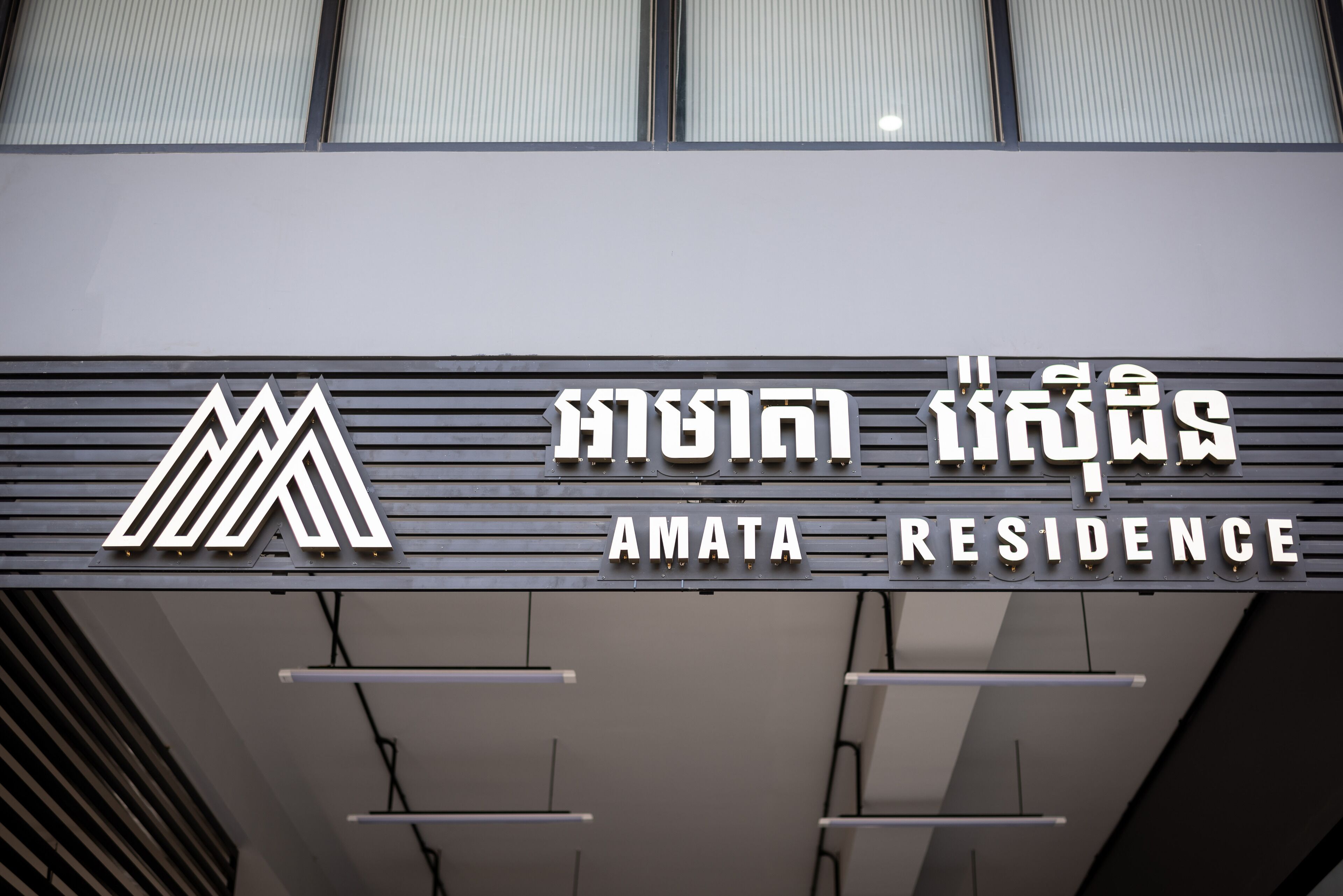 A sign for Amata Residence with a modern design and a logo.