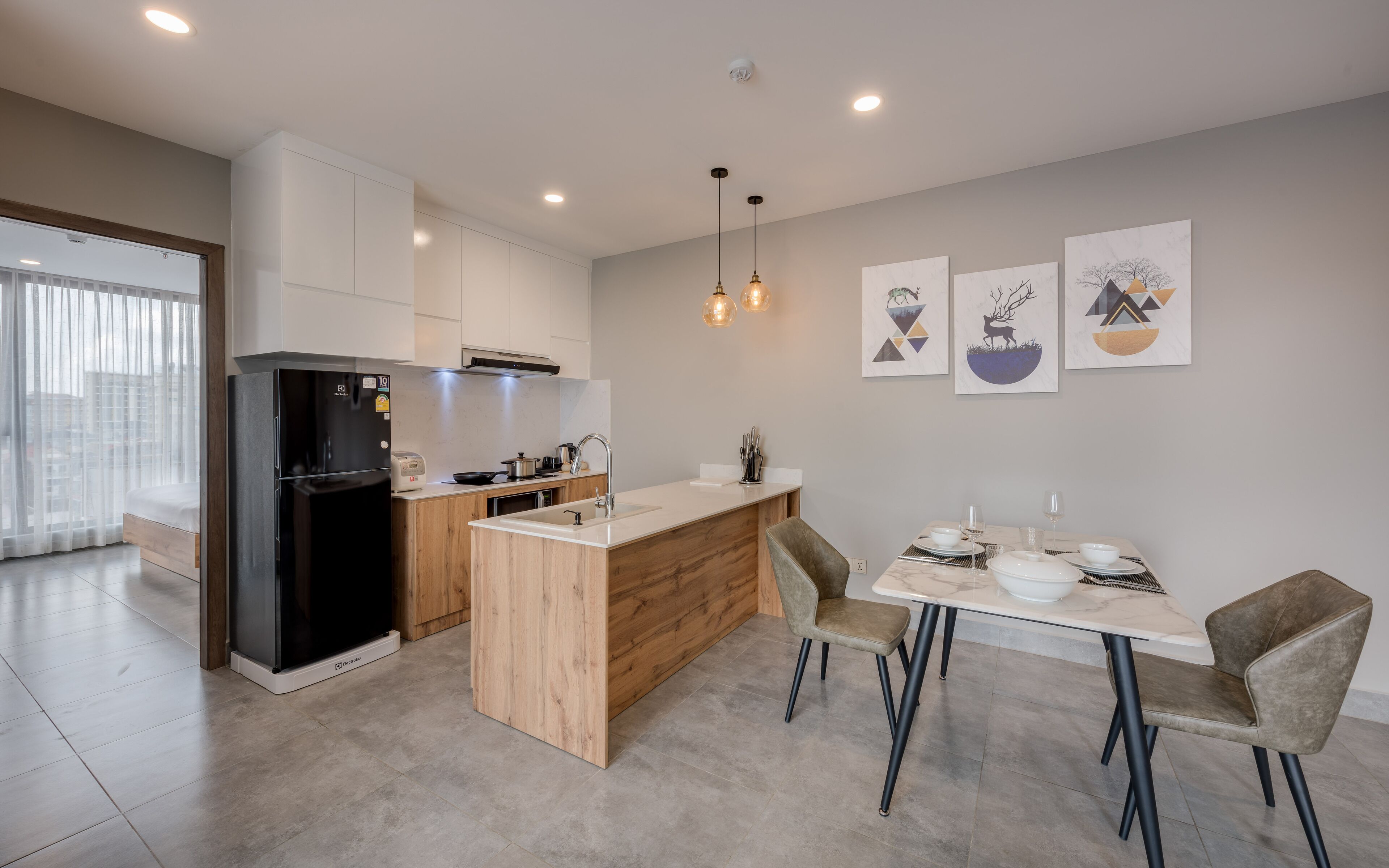 A modern kitchen with a central island, wooden cabinets, and a dining area with two chairs.