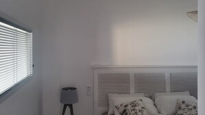 A bedroom with a bed, a standing lamp, a ceiling fan, and a window with blinds. - Only 4 View Rooftop Centre Sainte Anne (sainte anne)
