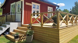 A red building with a wooden deck and steps leading to a door labeled "Franks Siga."