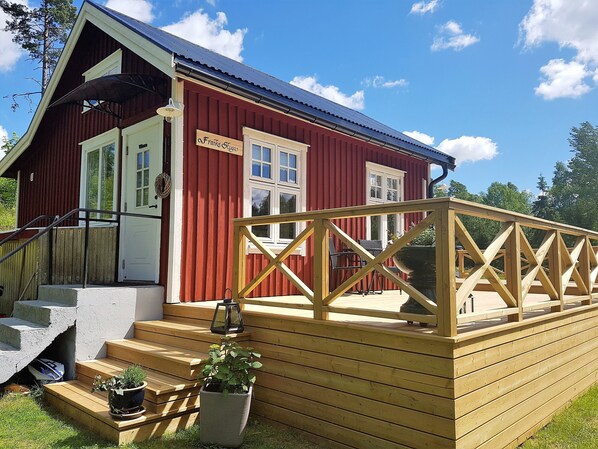 A red building with a wooden deck and steps leading to a door labeled "Franks Siga." - Charming Swedish house located in an exceptional natural setting, recently renovated, for 2 people (Ödskölt)