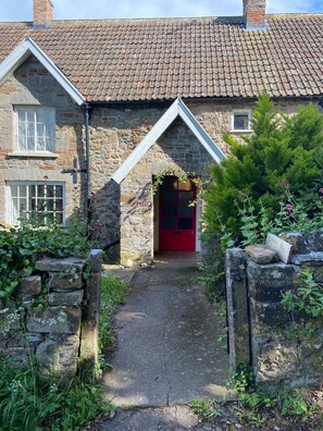 Traditional stone house with a charming entrance and garden area.