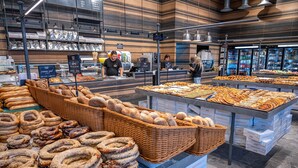Eine Bäckertheke mit verschiedenen Backwaren und einem Kühlregal im Hintergrund.