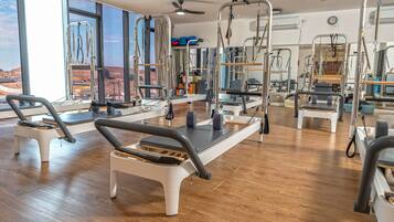 Un studio de Pilates doté de planchers en bois, de grandes fenêtres et de divers équipements d’exercice.