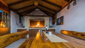 Une pièce chaleureuse avec une cheminée, des meubles en bois et un jeu de fléchettes.