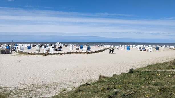 A beach with numerous white tents and a few blue structures, likely for accommodation or events, under a clear sky. - Vacation home in Altfunnixsiel/Carolinensiel (Wittmund)