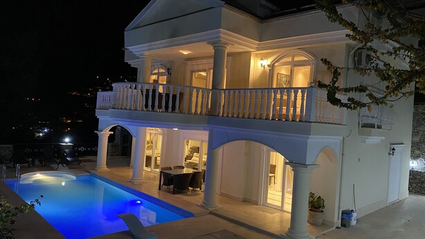 A two-story building with a swimming pool, outdoor seating, and a balcony with railings. - Fully detached Villa offers an unforgettable holiday with your family and friend (Alanya)