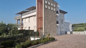 Een modern gebouw met twee verdiepingen, een stenen gevel en meerdere balkons.