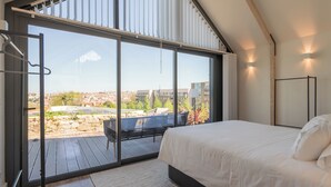 A bedroom with a large sliding glass door leading to an outdoor deck, a bed, and a nightstand. - FONTE SANTA Manor House (Vila Nova de Gaia)