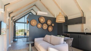 A modern interior with a sofa, dining table, and kitchen area. - FONTE SANTA Manor House (Vila Nova de Gaia)
