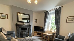 A living room with a fireplace, a television, and two sofas.