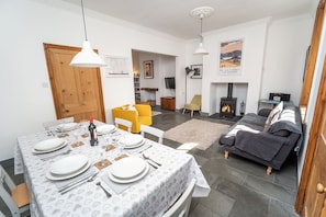 Una sala de estar moderna con comedor, chimenea y sofá.