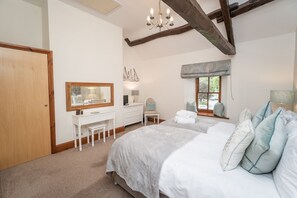 Un dormitorio con una cama grande, un aparador, un tocador y una ventana con vistas.