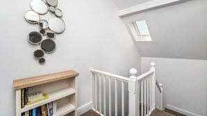 Eine moderne Treppe mit weißer Geländer und einem kleinen Oberlicht.