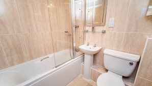 A bathroom with a bathtub, sink, and toilet. - 11 Howrah's Court -  an apartment that sleeps 4 guests  in 2 bedrooms (Central Keswick)