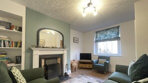 Ein Wohnzimmer mit Kamin, Fernseher und Bücherregal.