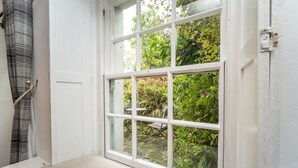 A room with a large window overlooking a garden. - Barf Cottage -  a cottage that sleeps 5 guests  in 3 bedrooms (Portinscale)