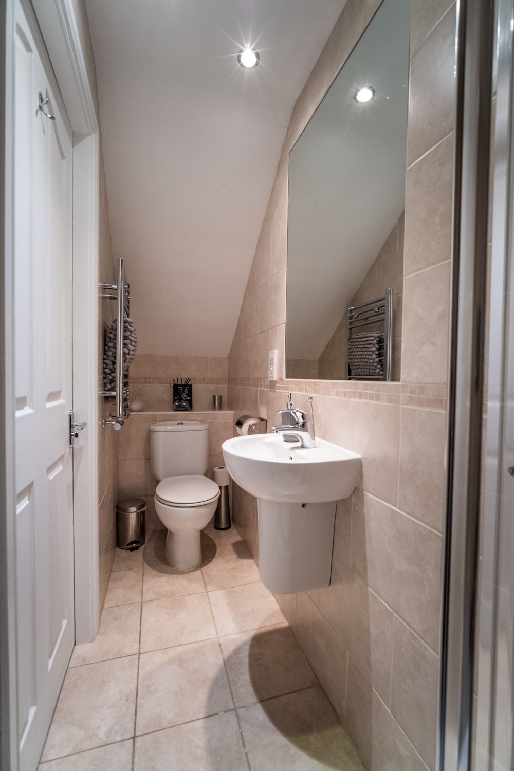 Een kleine badkamer met toilet, wastafel en douche.