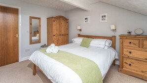 A bedroom with a bed, wooden wardrobe, a mirror, and a dresser. - Alban Rise -  a maisonette that sleeps 5 guests  in 3 bedrooms (Central Keswick)