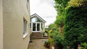 A house with a paved entrance and steps leading to a door.