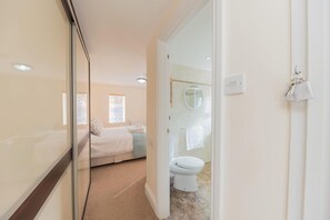 A bedroom with a bed, a bedside table, and a window.
