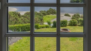 A window with a view of a lake, hills, and a grassy area. - Brandlehow -  a house that sleeps 7 guests  in 4 bedrooms (Portinscale)