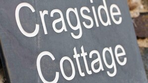 Een bord met de tekst 'Cragside Cottage'.