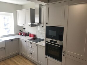 A modern kitchen with white cabinets, a Bosch oven, and a toaster.